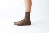 close-up of the embroidered luméa logo on the cacao pilates sock